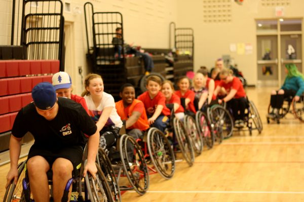 wheelchair athletes towing each other in a line